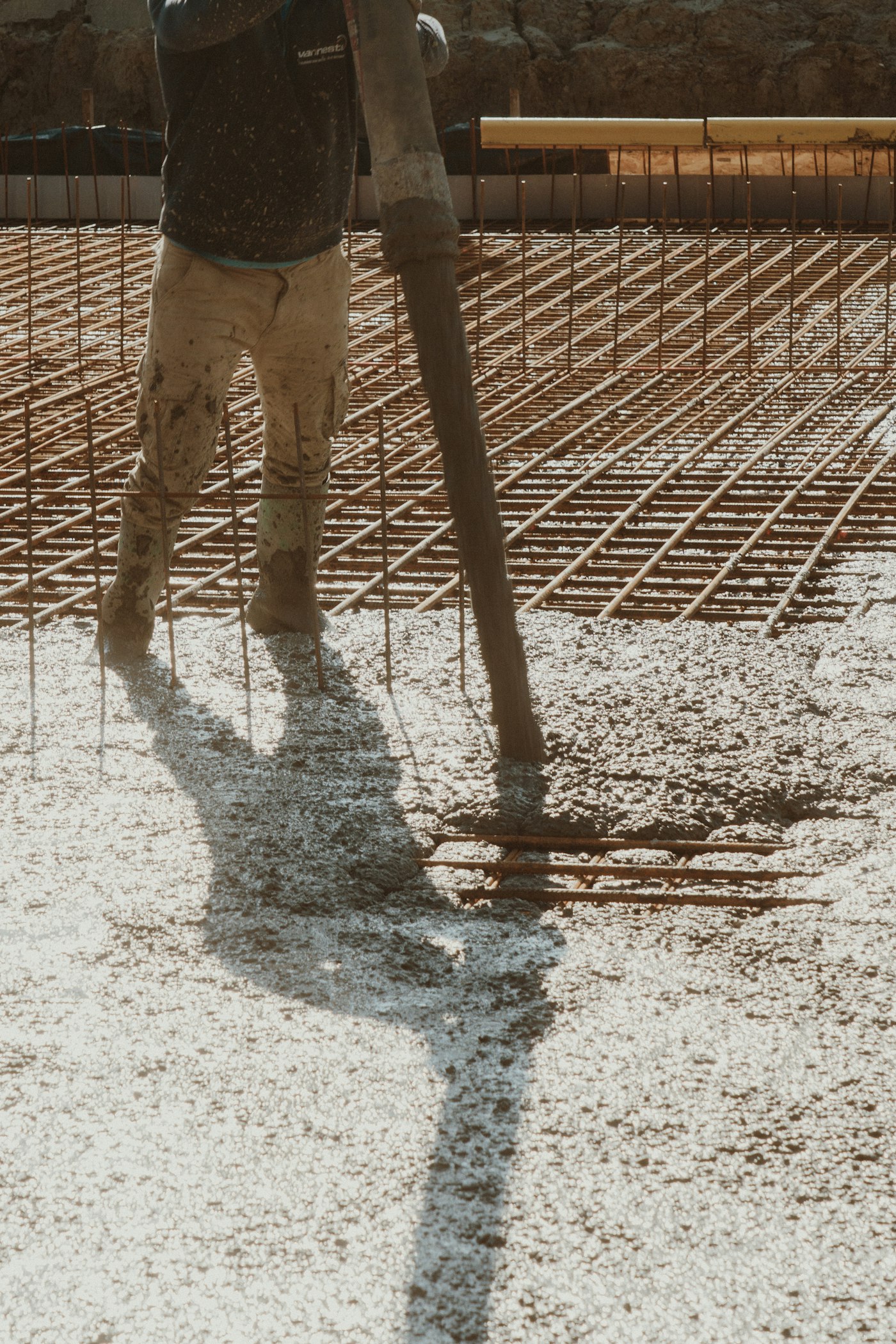 Concrete being placed over a rebar mat on a foundation slab