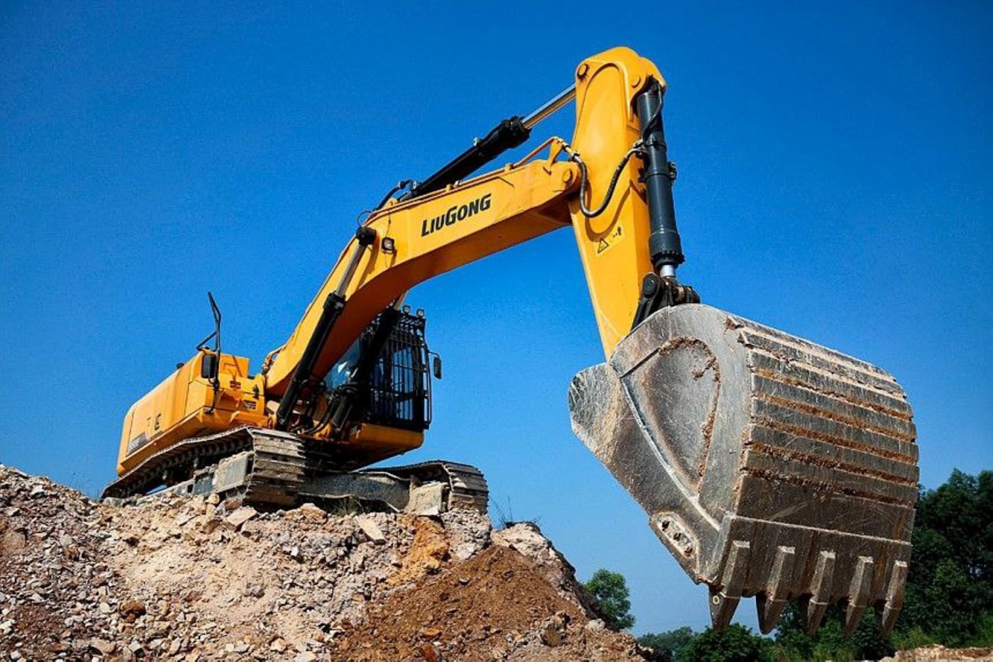 Excavator digging into a dirt bank on an active site