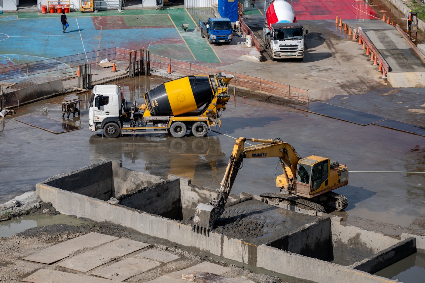 Concrete mixer truck and excavator working together on a site